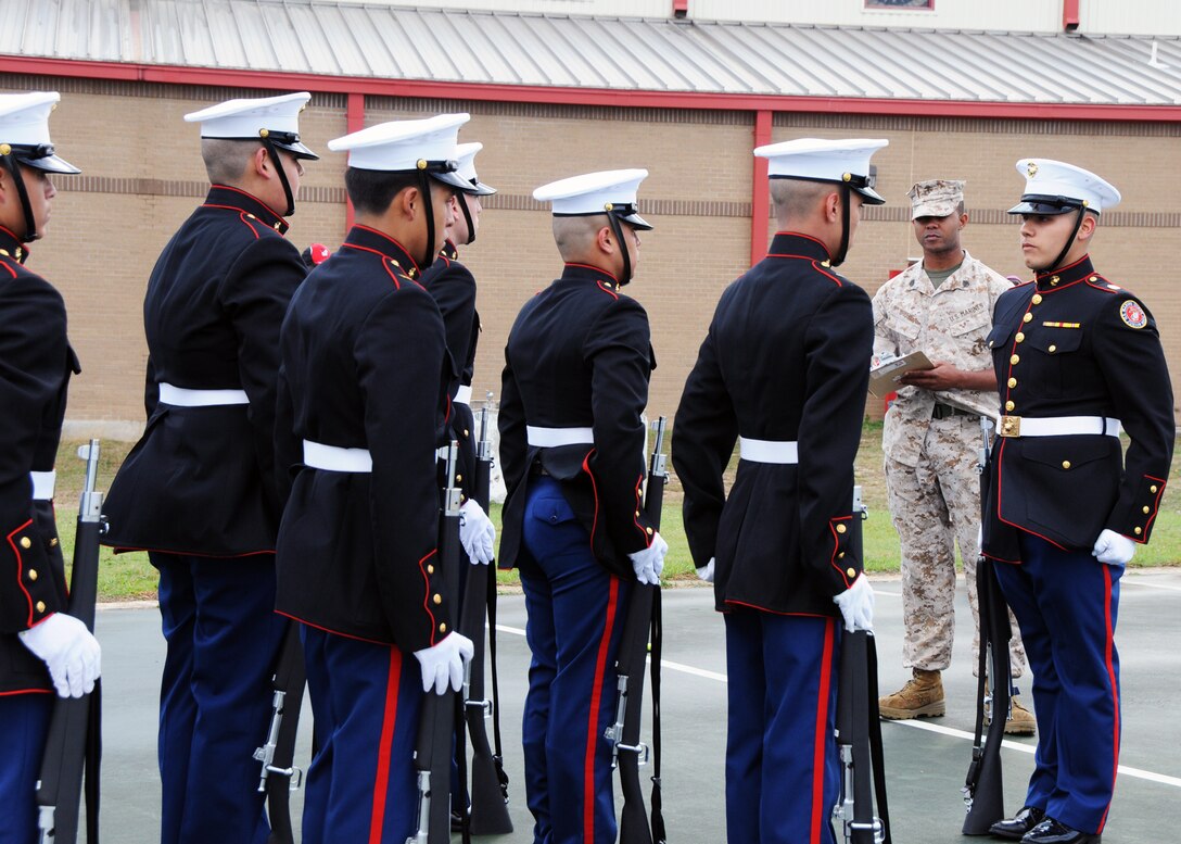 Staff Sgt. Mason Greene, in cammies, a recruiter from Marine Corps Recruiting Station San Antonio, Recruiting Sub-Station Austin North, grades Marine Corps Junior Reserve Officer Training Corps cadets from Donna High School on their performance at an all-Marine JROTC competition at Jack C. Hays High School, in Buda, Texas, March 5, 2011.
